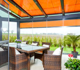 Ein Bild von einem Wintergarten, angebaut an ein Einfamilienhaus mit großzügigem Garten.